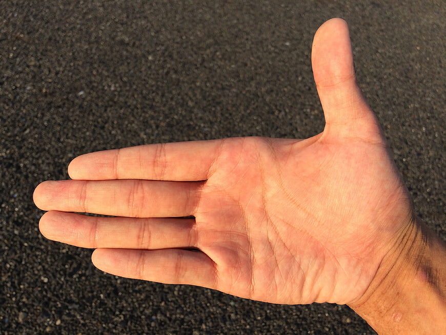 Close-up of open human palm on dark textured background