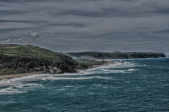 Dramatic coastal landscape with turquoise waves and lush cliffs