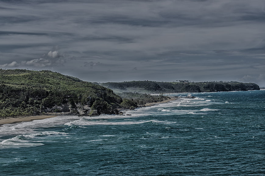 Dramatic coastal landscape with turquoise waves and lush cliffs