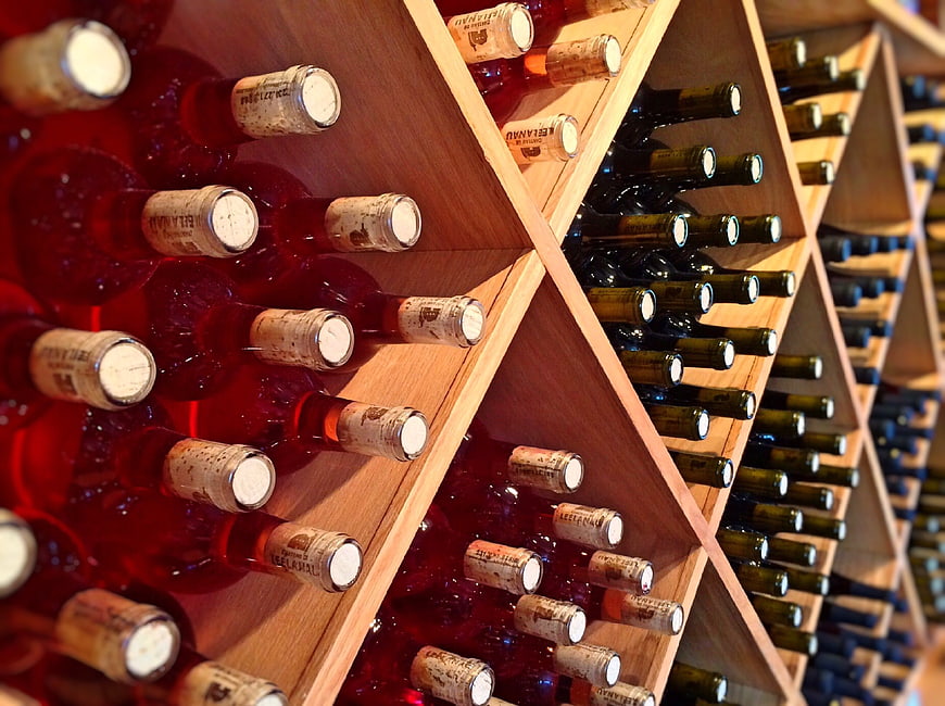 Red and Green Wine Bottles in Wooden Rack