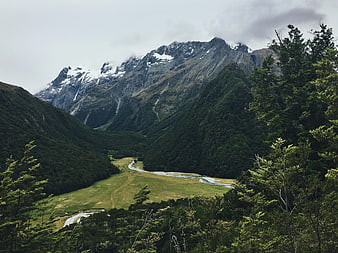 Majestic Snow-Capped Mountain Valley with River and Forest