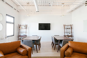 Modern office meeting room with leather sofas and wooden tables