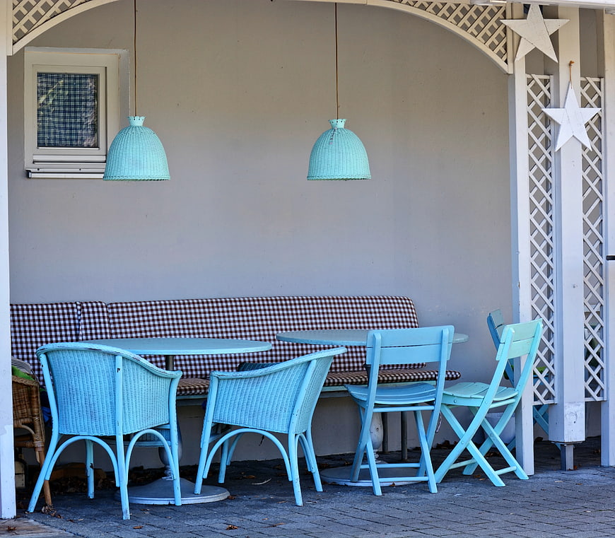 Light blue patio furniture with checkered bench and hanging lamps