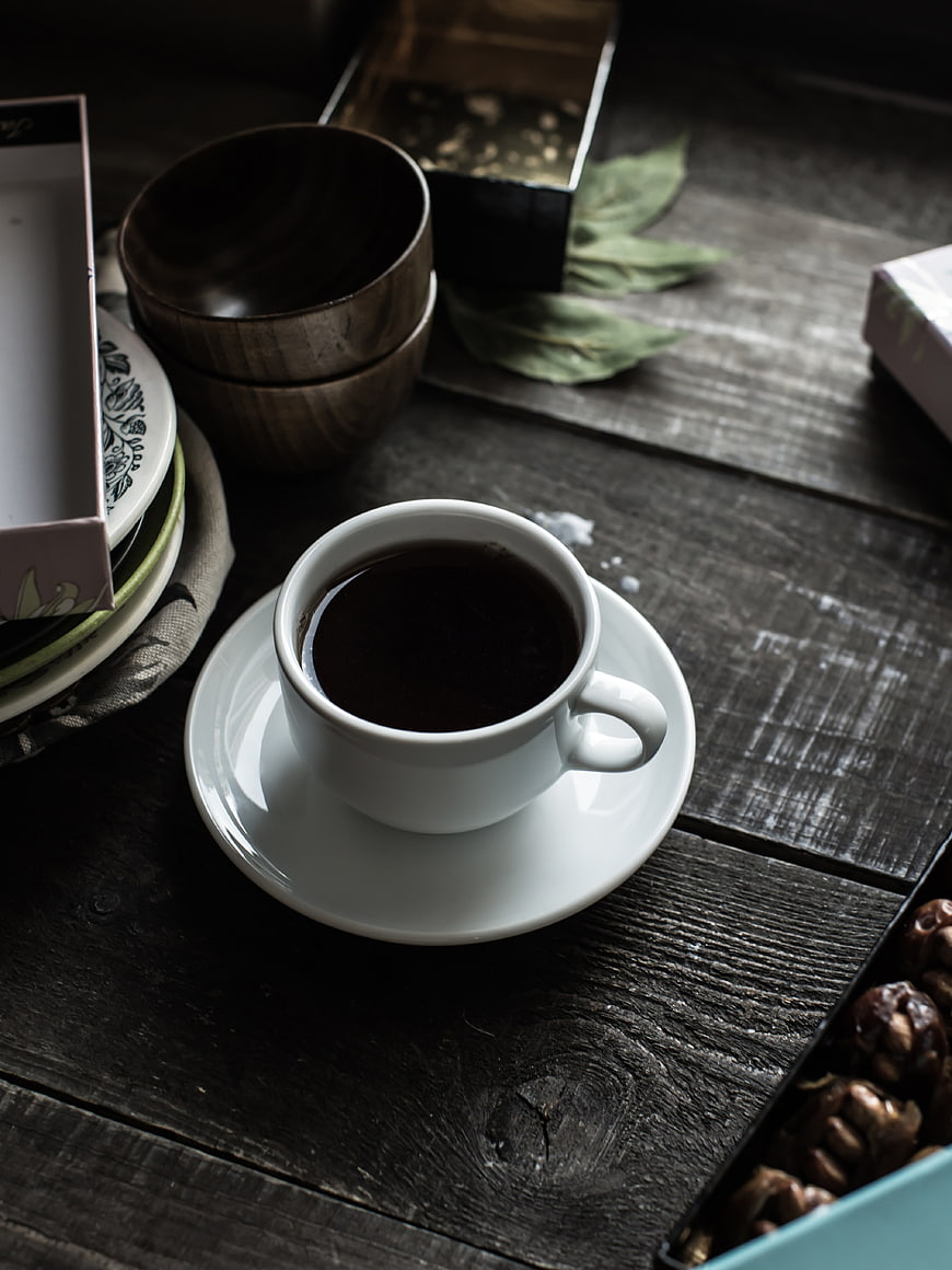 Dark moody cup of black coffee on rustic wooden table