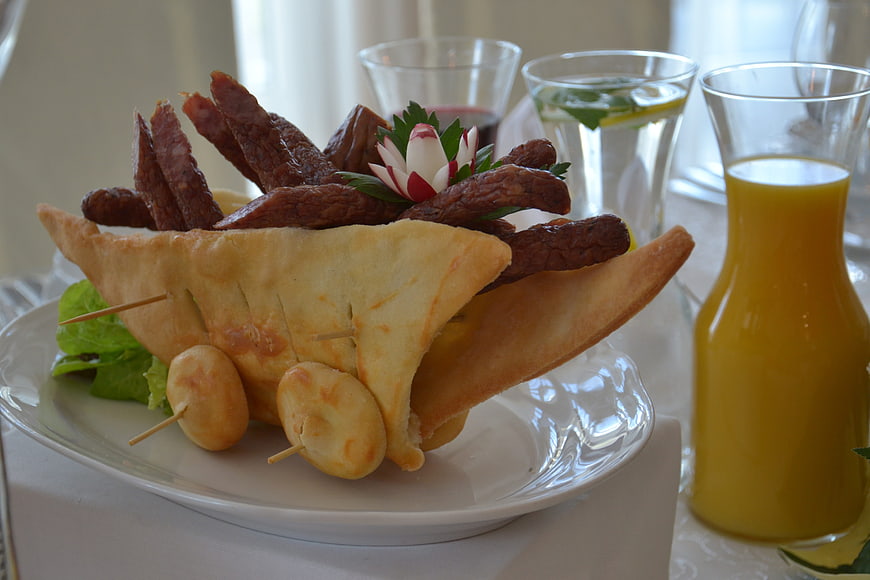 Creative bread boat appetizer with cured meat and orange juice