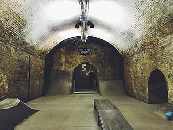 Underground brick tunnel skatepark with ramps and rails