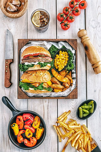 Top view of gourmet burgers with fries and roasted vegetables