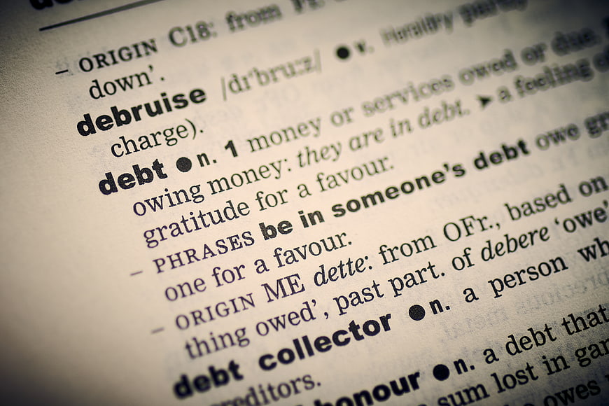Close-up of dictionary definition for the word debt