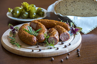 Gourmet sausages with rosemary and peppercorns on wooden board