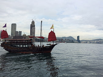 Traditional Chinese Junk Boat Sailing in Hong Kong Harbor