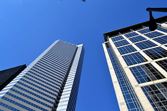 Low angle view of modern glass skyscrapers against a clear blue sky