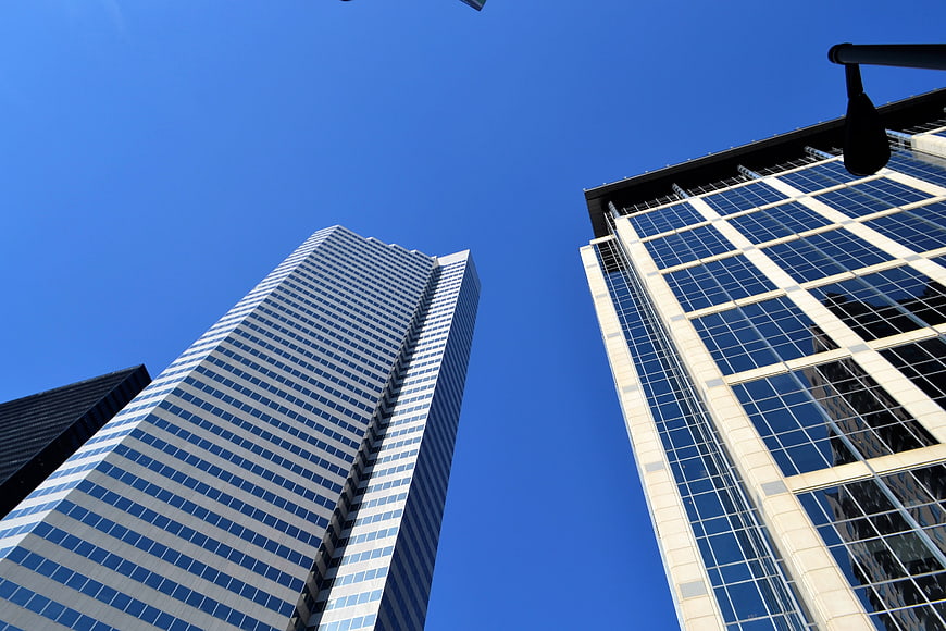 Low angle view of modern glass skyscrapers against a clear blue sky