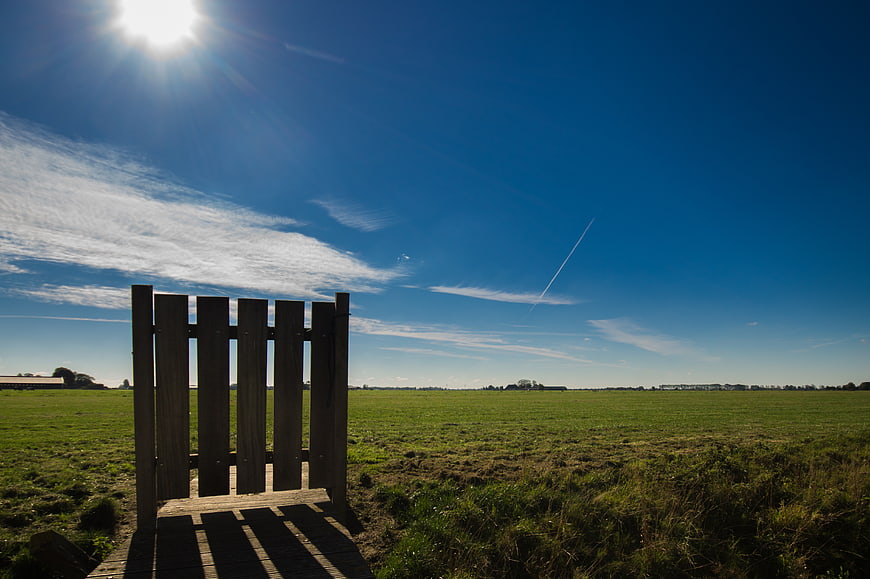 Wooden Gate in Green Meadow Under Blue Sky