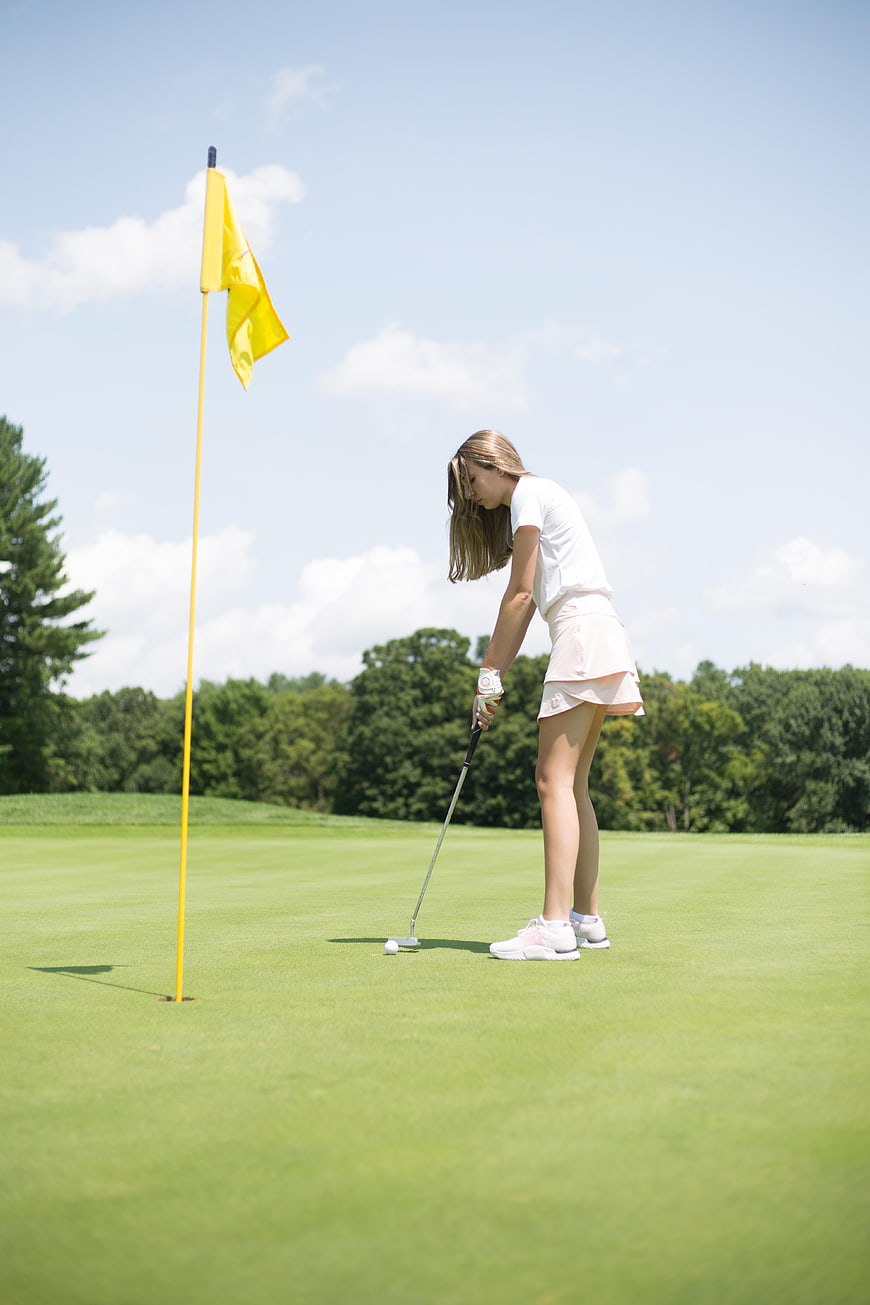 Young Woman Putting on Golf Course Green