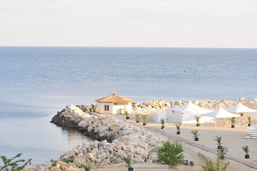 Serene coastal resort with stone breakwater and white tents