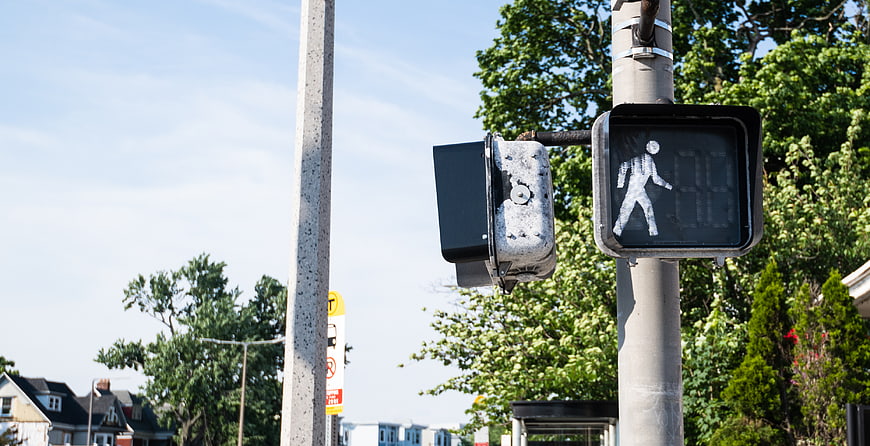 Pedestrian Crossing Signal with Walk Symbol on Urban Street