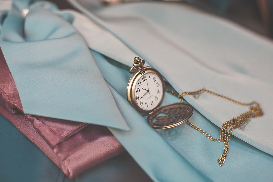 Vintage pocket watch on light blue shirt and tie