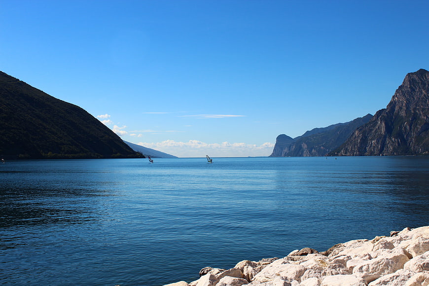 Windsurfers on Lake Garda with Mountains and Blue Sky