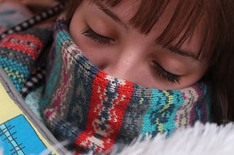 Close-up of woman sleeping with colorful knitted scarf