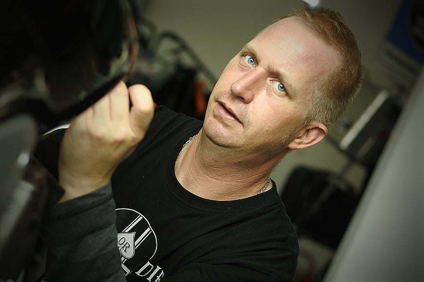 Mechanic inspecting motorcycle engine with intense focus