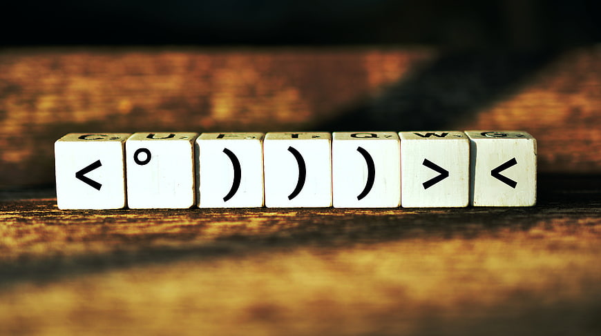 Scrabble Tiles Spelling Smiley Face On Wooden Table