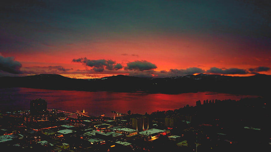 Dramatic Red Sunset Over Coastal City and Mountains
