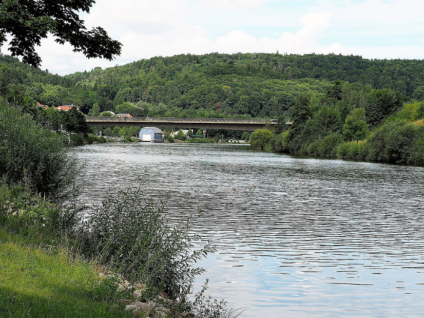 Scenic River Landscape with Bridge and Forested Hills