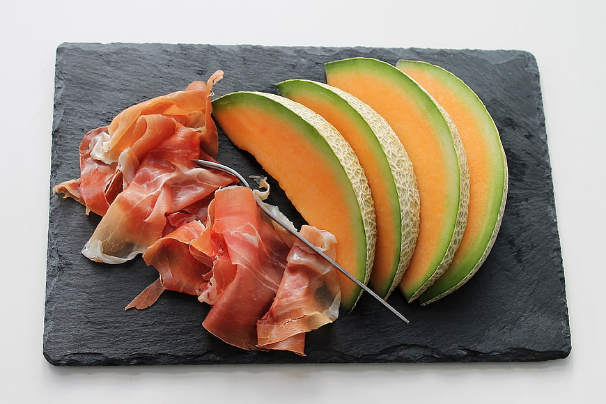 Sliced Cantaloupe Melon and Prosciutto on Slate Board