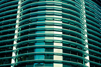 Abstract teal curved glass facade of modern office building