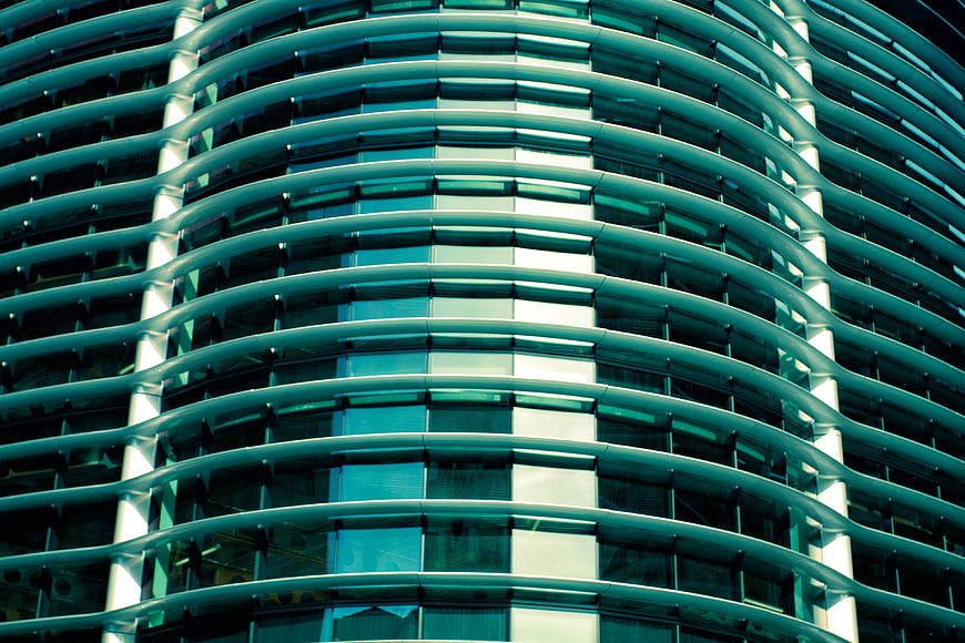 Abstract teal curved glass facade of modern office building