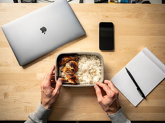 Overhead view of healthy chicken and rice lunch on office desk