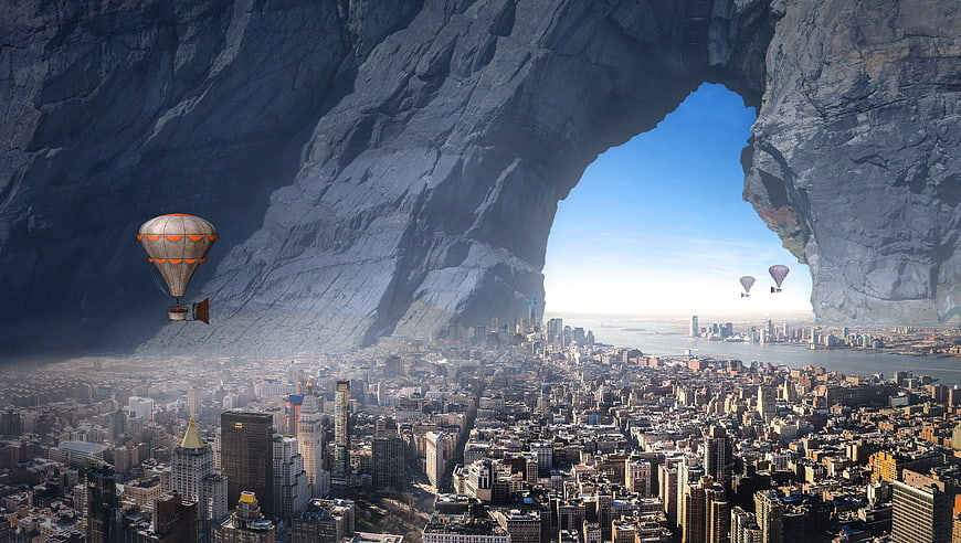 Surreal cityscape with hot air balloons emerging from a giant cave