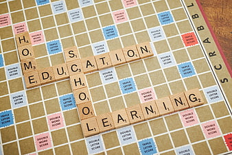 Scrabble board with words education, home, school, and learning