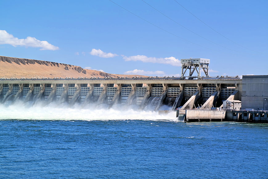 Hydroelectric dam releasing water into a blue river