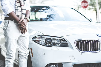 Man in Scarf Standing Next to White BMW Car