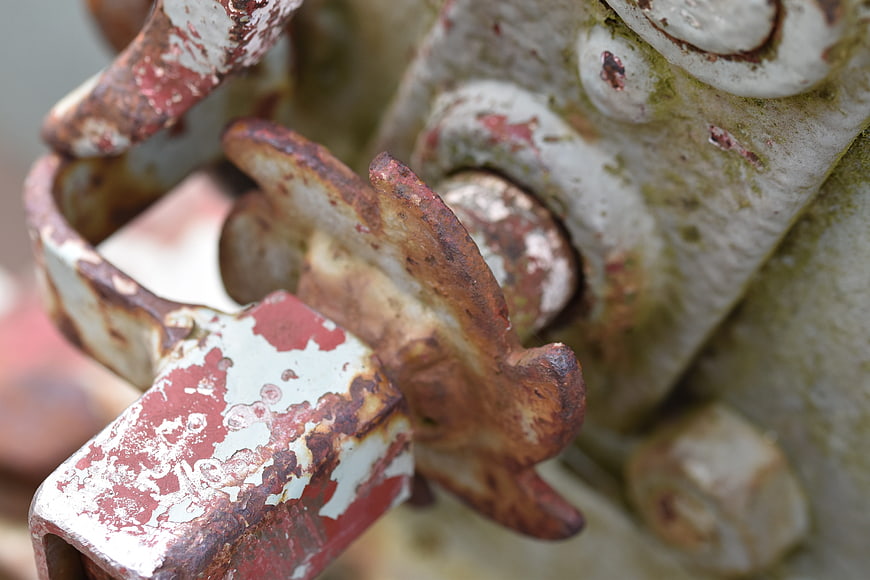 Close-up of rusty metal padlock on industrial gate