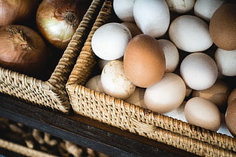 Fresh brown and white eggs in woven baskets