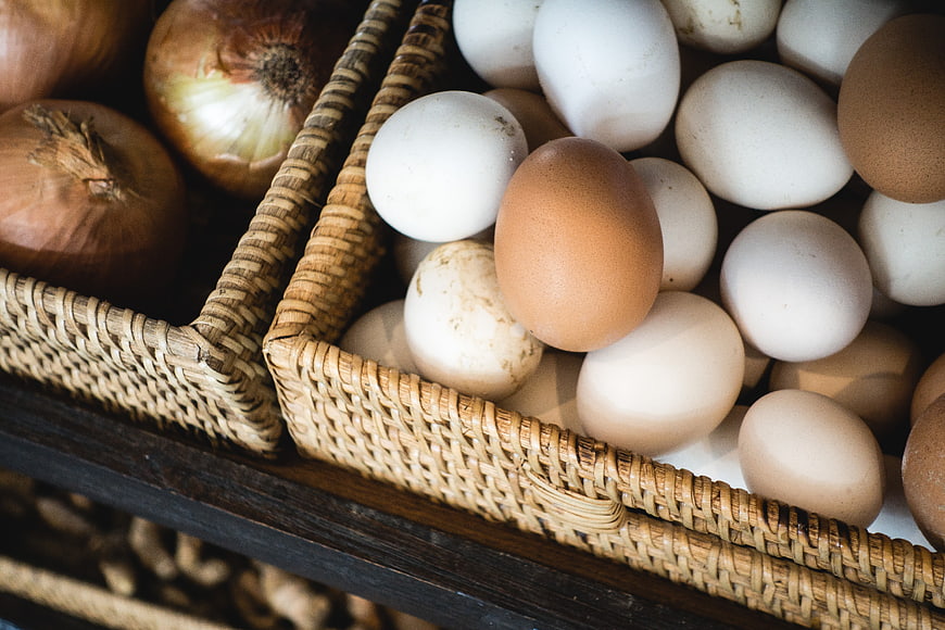 Fresh brown and white eggs in woven baskets