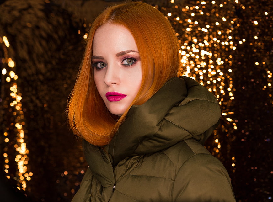Portrait of Redhead Woman in Green Jacket with Bokeh Lights