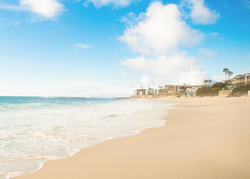 Sunny Beach Landscape with Ocean Waves and Coastal Houses