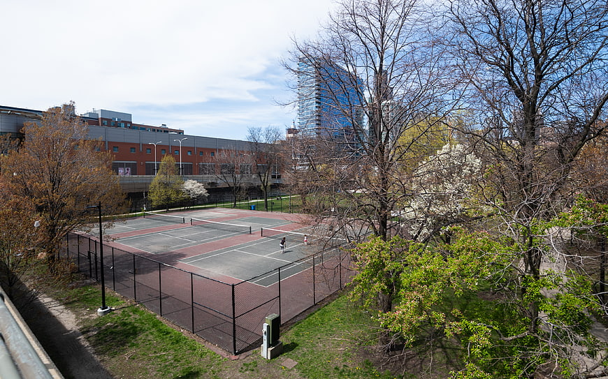 Outdoor Tennis Courts in Urban Park with City Skyline