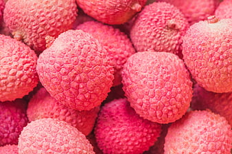 Close-up of fresh pink lychee fruits with textured skin