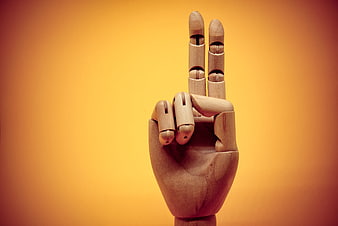 Wooden Hand Gesture Showing Number Two on Orange Background