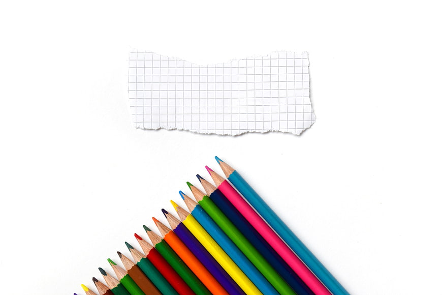 Colorful Pencils and Graph Paper on White Background