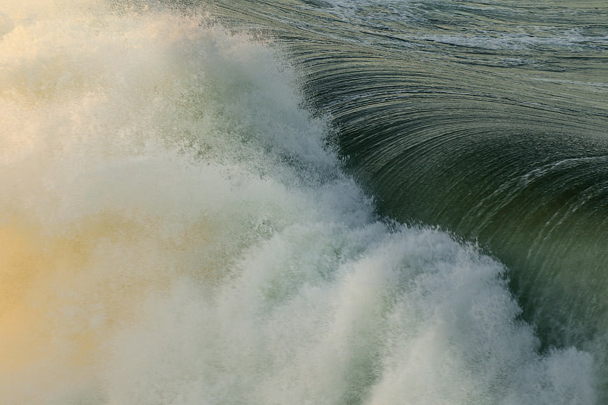 Close-up of crashing ocean wave with white foam and green water