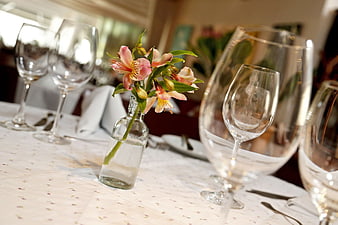 Elegant table setting with wine glasses and pink flowers