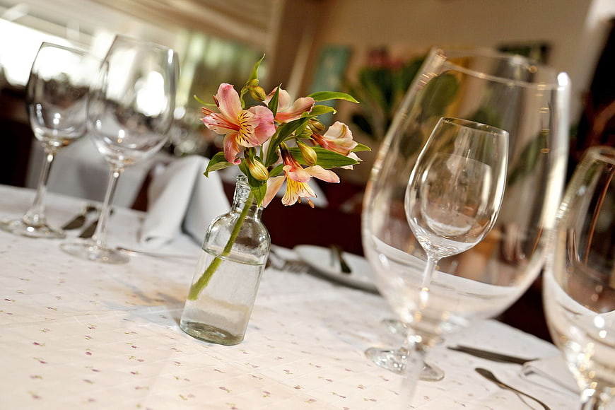 Elegant table setting with wine glasses and pink flowers