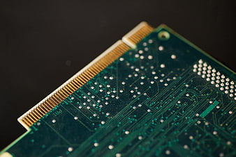 Close-up of green circuit board with gold connector pins