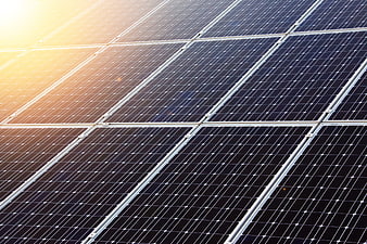 Close-up of solar panels with golden sunlight reflection