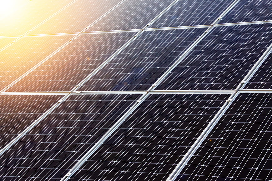 Close-up of solar panels with golden sunlight reflection